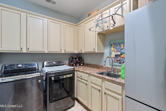 laundry room with sink, independent washer and dryer, and cabinets