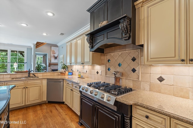 kitchen featuring light hardwood / wood-style floors, stainless steel appliances, ornamental molding, and cream cabinetry