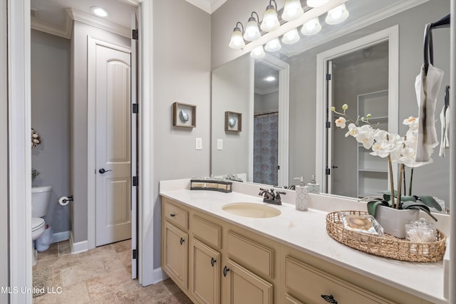 bathroom featuring toilet, crown molding, and vanity