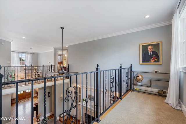 corridor with crown molding, an inviting chandelier, and hardwood / wood-style floors