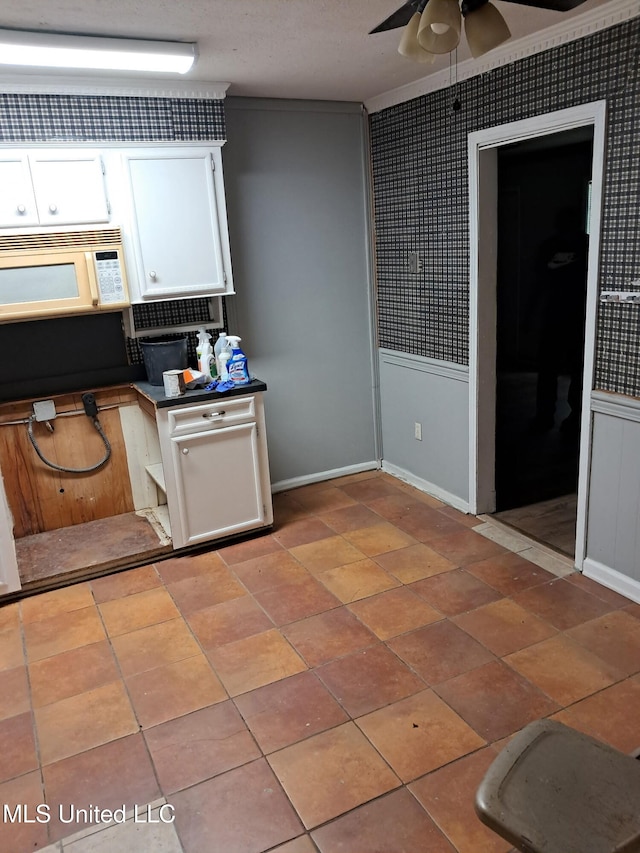 2943 Suncrest Dr, Jackson, MS 39212 - kitchen with dark countertops, ceiling fan, white cabinetry, white microwave, and baseboards