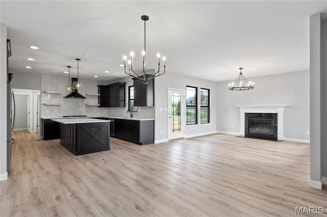 1 Hadleigh, Windsor Park, Lake St Louis, MO 63367 - kitchen with a chandelier, dark cabinets, light countertops, a center island, and tasteful backsplash
