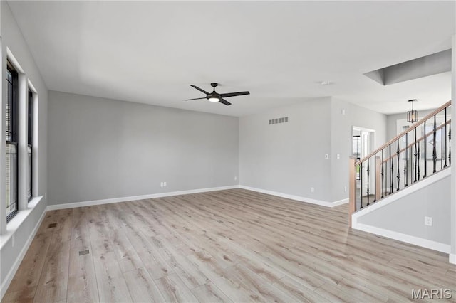 1 Hadleigh, Windsor Park, Lake St Louis, MO 63367 - empty room with wood finished floors, stairs, baseboards, ceiling fan, and a chandelier