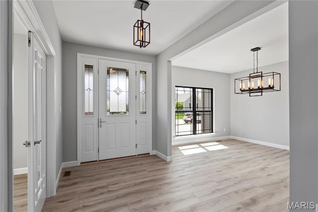 1 Hadleigh, Windsor Park, Lake St Louis, MO 63367 - entryway with a chandelier, baseboards, and light wood-style floors