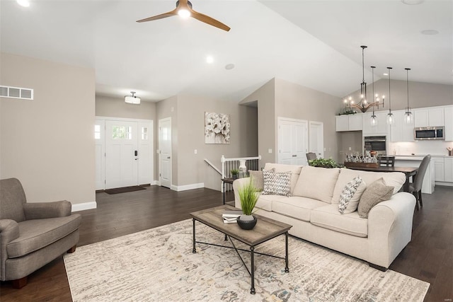 living room with ceiling fan, dark wood-style flooring, high vaulted ceiling, baseboards, and a chandelier
