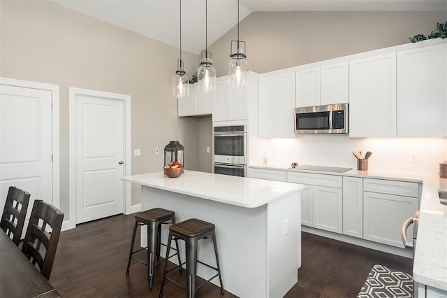 kitchen with stainless steel appliances, dark wood-type flooring, high vaulted ceiling, white cabinetry, and a kitchen breakfast bar