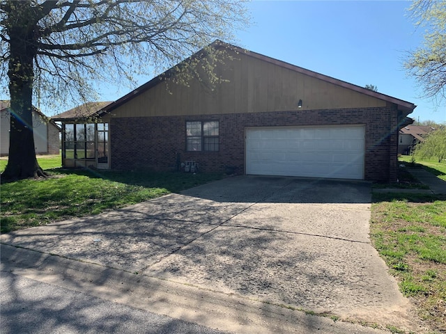 400 University Dr, Belleville, IL 62226 - view of property exterior with brick siding, driveway, an attached garage, a lawn, and a sunroom