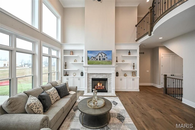 712 Silver Buck Ln, Chesterfield, MO 63005 - living room with a high ceiling, wood finished floors, a stone fireplace, recessed lighting, and built in shelves