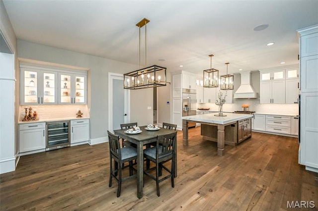 712 Silver Buck Ln, Chesterfield, MO 63005 - dining space with wine cooler, dark wood-style floors, a dry bar, recessed lighting, and a chandelier