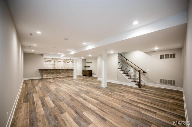 712 Silver Buck Ln, Chesterfield, MO 63005 - unfurnished living room featuring wood finished floors, stairway, recessed lighting, and bar area
