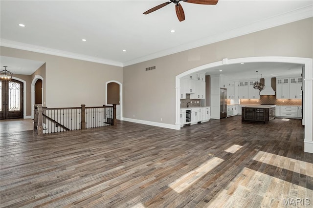 724 Silver Buck Ln, Chesterfield, MO 63005 - unfurnished living room featuring ceiling fan, dark wood finished floors, crown molding, recessed lighting, and wine cooler