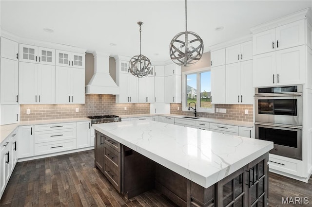 724 Silver Buck Ln, Chesterfield, MO 63005 - kitchen featuring premium range hood, appliances with stainless steel finishes, a chandelier, dark wood-type flooring, and white cabinets