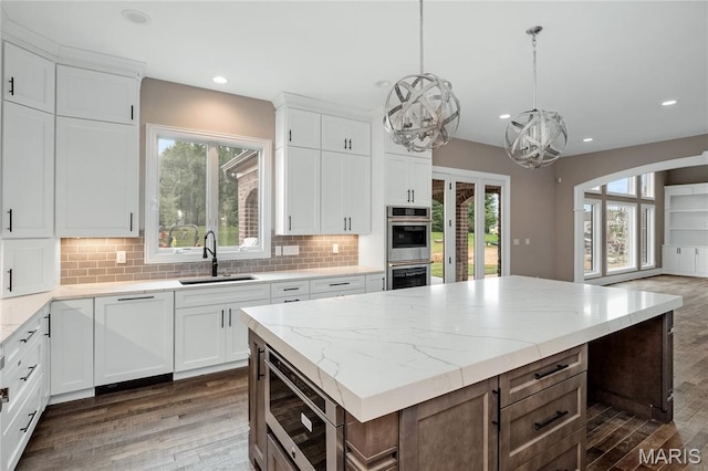 724 Silver Buck Ln, Chesterfield, MO 63005 - kitchen featuring stainless steel microwave, dark wood-style flooring, a chandelier, tasteful backsplash, and recessed lighting