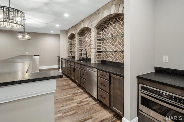 724 Silver Buck Ln, Chesterfield, MO 63005 - kitchen with appliances with stainless steel finishes, light wood-style floors, dark countertops, recessed lighting, and hanging light fixtures