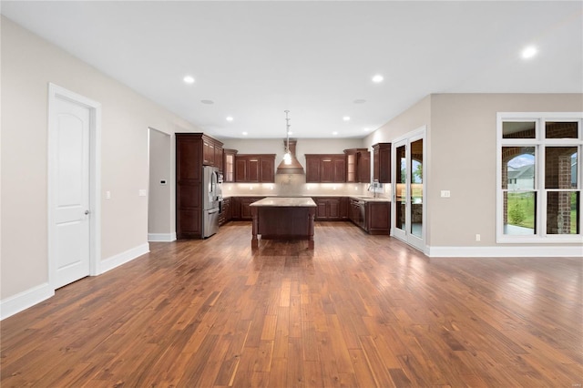 744 Silver Buck Ln, Chesterfield, MO 63005 - kitchen featuring stainless steel refrigerator, a kitchen island, dark wood-style floors, custom range hood, and light countertops