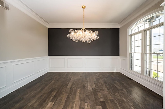 unfurnished dining area featuring a chandelier, healthy amount of natural light, dark wood-style flooring, ornamental molding, and wainscoting