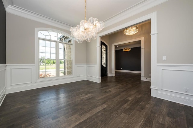 unfurnished dining area with a chandelier, ornamental molding, a decorative wall, dark wood-style flooring, and a wainscoted wall