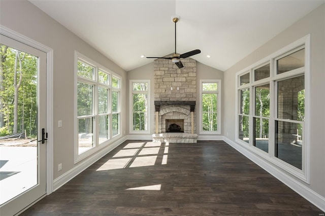unfurnished living room featuring ceiling fan, dark wood-style floors, lofted ceiling, and a fireplace