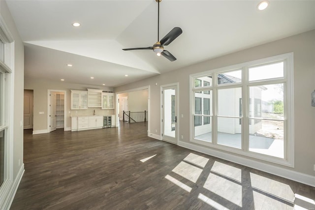 unfurnished living room featuring lofted ceiling, baseboards, dark wood-style flooring, a ceiling fan, and recessed lighting