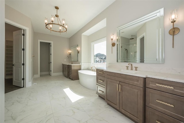 full bath featuring marble look tiles, a chandelier, a shower stall, a soaking tub, and vanity