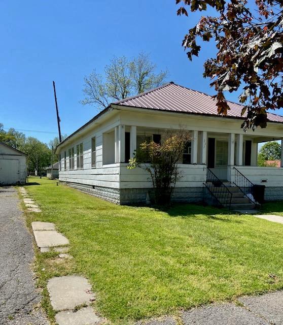 332 S Elm, Dexter, MO 63841 - view of side of home featuring crawl space, a lawn, and metal roof