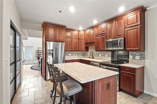 505 N And S Rd Unit 3C, University City, MO 63130 - kitchen with appliances with stainless steel finishes, tasteful backsplash, a breakfast bar area, a kitchen island, and recessed lighting