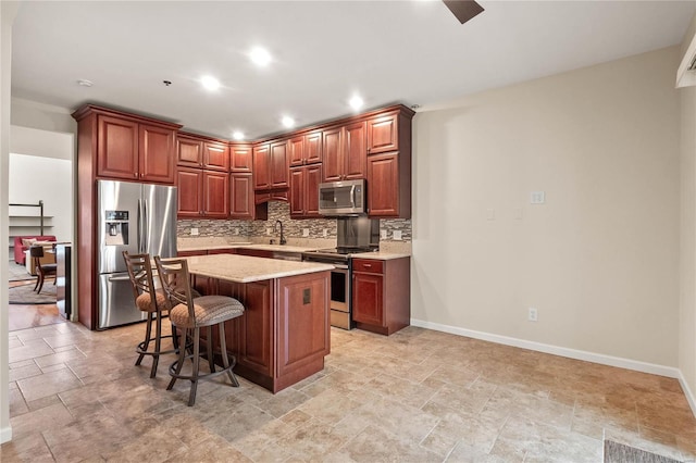 505 N And S Rd Unit 3C, University City, MO 63130 - kitchen with appliances with stainless steel finishes, tasteful backsplash, baseboards, a center island, and light stone finish flooring