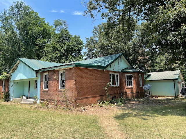 502 Chautauqua, Dexter, MO 63841 - view of side of property with brick siding, a lawn, and metal roof
