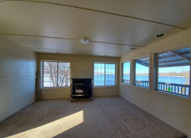 801 S Front St, La Grange, MO 63448 - unfurnished living room featuring baseboards, a multi sided fireplace, carpet flooring, and a water view