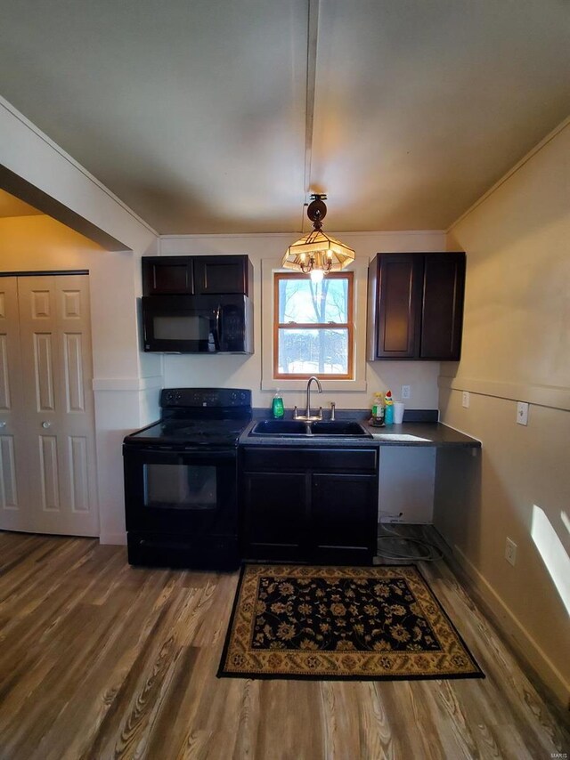 801 S Front St, La Grange, MO 63448 - kitchen featuring black appliances, a sink, dark wood finished floors, dark countertops, and hanging light fixtures