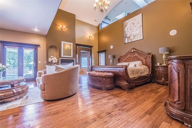 6708 Brown Ln, Poplar Bluff, MO 63901 - bedroom with a chandelier, wood finished floors, high vaulted ceiling, and access to outside