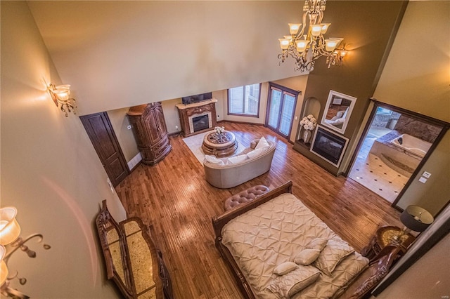 6708 Brown Ln, Poplar Bluff, MO 63901 - living room with a premium fireplace, a towering ceiling, wood finished floors, a chandelier, and baseboards