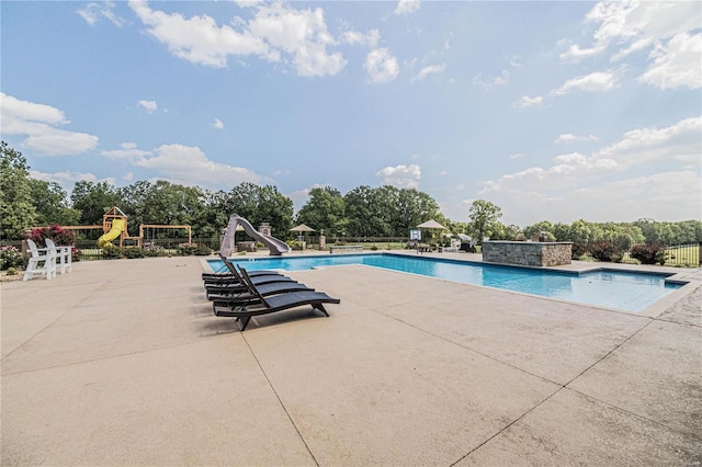 6708 Brown Ln, Poplar Bluff, MO 63901 - view of pool with a water slide, a patio, fence, and view of wooded area