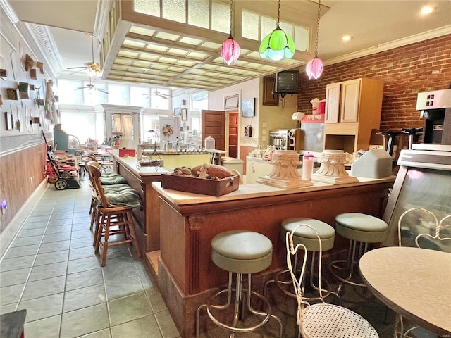 207 S Main St, Hannibal, MO 63401 - bar area with a ceiling fan, plenty of natural light, crown molding, brick wall, and light tile patterned floors