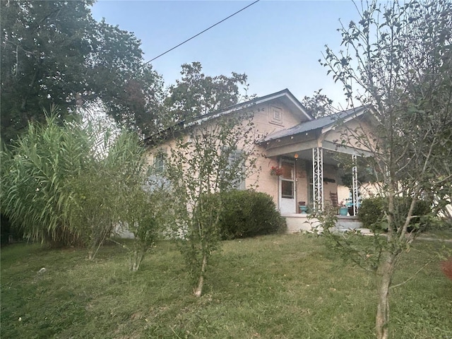 1409 Spring St, Poplar Bluff, MO 63901 - view of property exterior featuring a yard and stucco siding