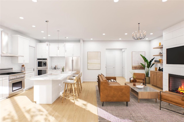 132 E Monroe Unit B-212, Saint Louis, MO 63122 - living room with recessed lighting, light wood-style floors, a chandelier, a tiled fireplace, and baseboards