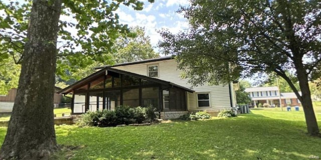 rear view of house with a sunroom and a yard