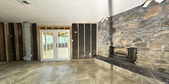 unfurnished living room featuring french doors and a fireplace