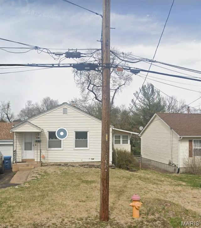bungalow-style home with a front lawn