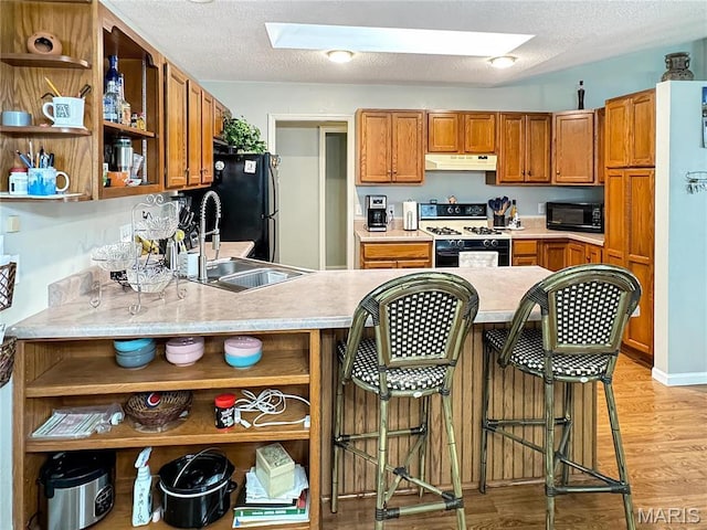 21 Forest Ln, Union, MO 63084 - kitchen featuring open shelves, gas range oven, black microwave, under cabinet range hood, and a textured ceiling