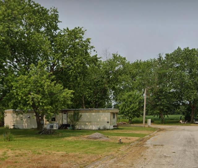 view of grassy yard featuring asphalt driveway