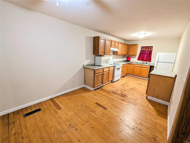 1035 Park Ave, Poplar Bluff, MO 63901 - kitchen with white appliances, a sink, light countertops, baseboards, and light wood-style flooring