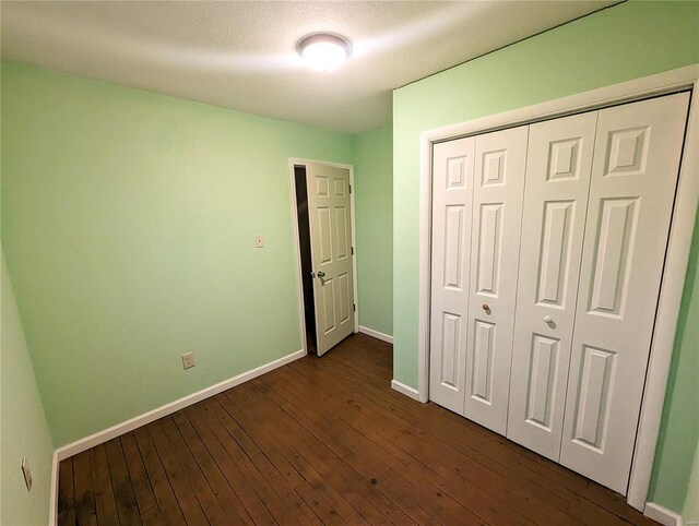 1035 Park Ave, Poplar Bluff, MO 63901 - unfurnished bedroom with dark wood-style floors, baseboards, and a closet