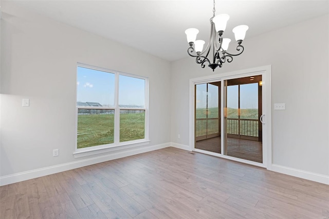 144 Columbia Meadows C Ln, Ofallon, MO 63366 - empty room with a chandelier, plenty of natural light, baseboards, and wood finished floors