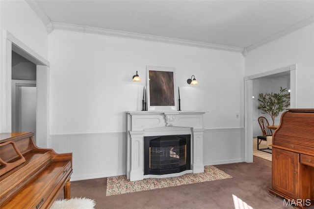 living room with crown molding, a wainscoted wall, carpet, and a fireplace
