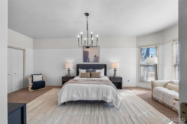 carpeted bedroom featuring a chandelier and baseboards