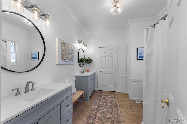 full bathroom with crown molding, two vanities, and baseboards
