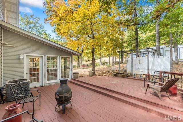 wooden terrace with an outdoor fire pit and central AC