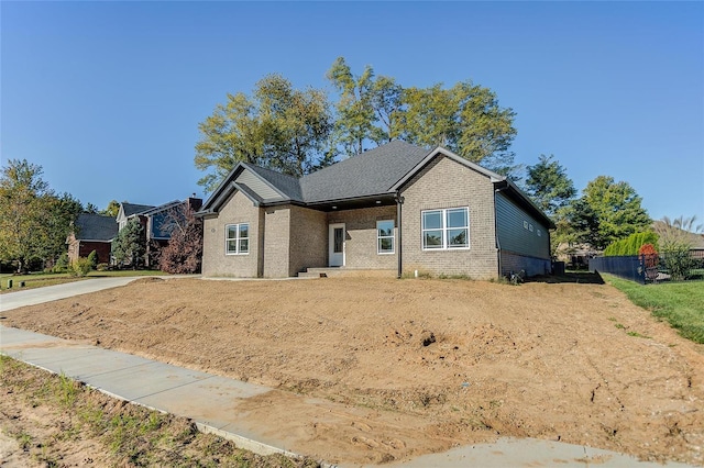 view of front of home with brick siding and fence
