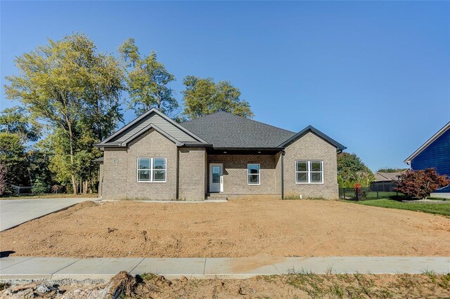 view of front of property with brick siding and fence